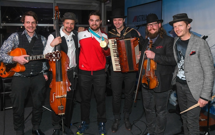 Die Musiker bei Olympia 2018 mit Rodler und Goldmedaillengewinner David Gleirscher.