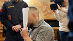 Der Mordangeklagte versteckte im Verhandlungssaal sein Gesicht vor den Kameras.