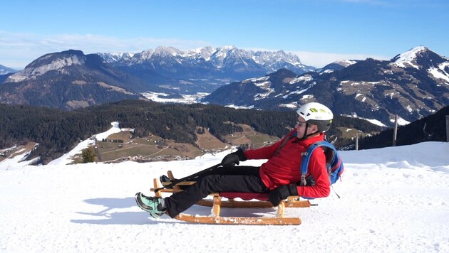 Der Wilde Kaiser (im Hintergrund) bildet einen Teil der Kulisse während der Rodelpartie in der ...
