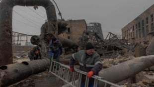 Mitarbeiter reparieren Teile des durch russische Luftangriffe beschädigten Heizkraftwerks ...