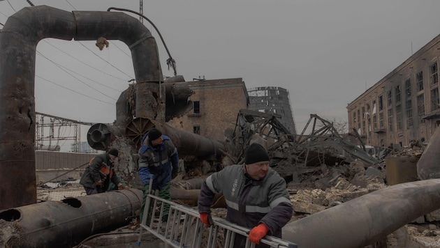 Mitarbeiter reparieren Teile des durch russische Luftangriffe beschädigten Heizkraftwerks ...