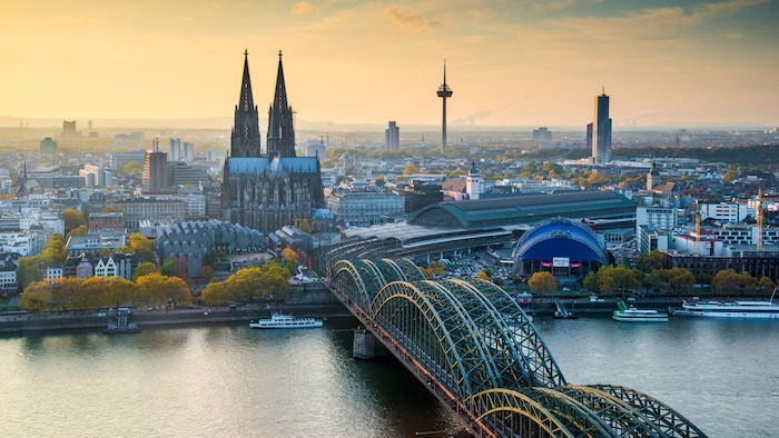 Der Kölner Dom ragt über die Ufer des Rheins.