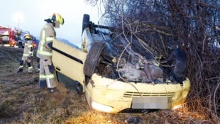 Der demolierte Pkw am Dach liegend neben der Autobahn 