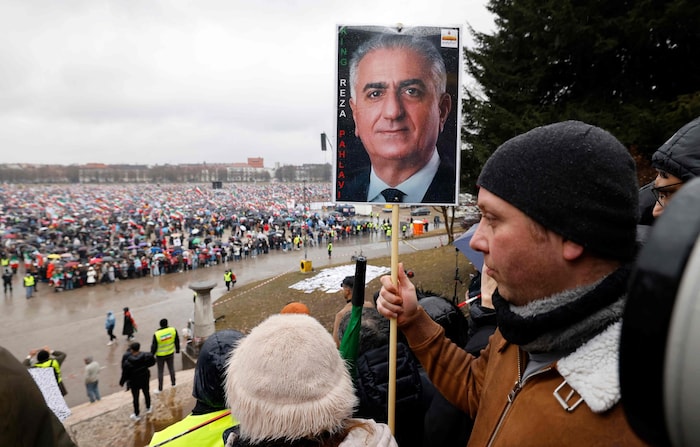 Ein Demonstrant hält in München ein Bild von Reza Pahlavi hoch.