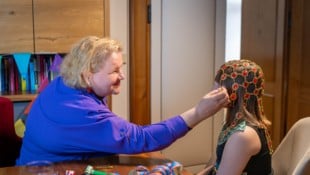 Ministerin Korinna Schumann hilft einem Mädchen bei den Faschingsvorbereitungen. 