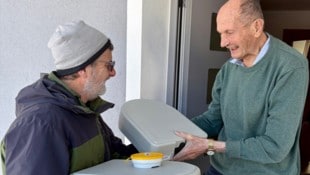 Freiwillige wie Klaus Schmidt (li.) überbringen in Goldegg das Essen an die Senioren. 