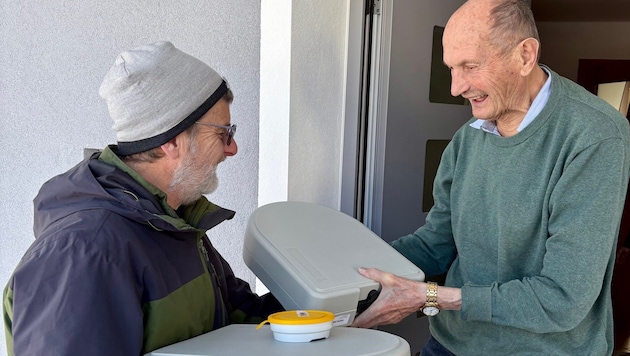 Freiwillige wie Klaus Schmidt (li.) überbringen in Goldegg das Essen an die Senioren.