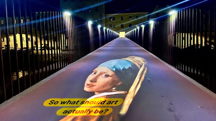 Ennssteg mit der Projektion von Jan Vermeers Kultbild „Das Mädchen mit dem Perlenohrring“.