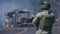 Ein mexikanischer Soldat hält am Schauplatz von nach der Tötung von Drogen-Boss „El Mencho“ ...
