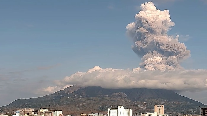 Der Sakurajima liegt direkt gegenüber dem Zentrum der Hafenstadt Kagoshima (am Bildunterrand zu ...
