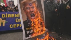 Proiranische Demonstranten verbrennen ein antisemitisches Porträt des US-Präsidenten.