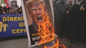 Proiranische Demonstranten verbrennen ein antisemitisches Porträt des US-Präsidenten.