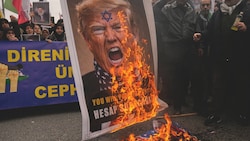 Proiranische Demonstranten verbrennen ein antisemitisches Porträt des US-Präsidenten.