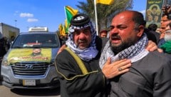 Mitglieder der Hisbollah liegen sich in den Armen und weinen um Ayatollah Ali Khamenei.