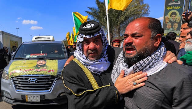 Mitglieder der Hisbollah liegen sich in den Armen und weinen um Ayatollah Ali Khamenei.