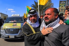 Mitglieder der Hisbollah liegen sich in den Armen und weinen um Ayatollah Ali Khamenei.