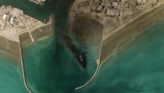 Rauchwolken und ein zerstörtes Schiff im Hafen von Bandar Abbas an der Straße von Hormuz