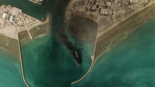 Rauchwolken und ein zerstörtes Schiff im Hafen von Bandar Abbas an der Straße von Hormuz