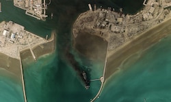 Rauchwolken und ein zerstörtes Schiff im Hafen von Bandar Abbas an der Straße von Hormuz