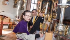 Armin Puschl beim Anzünden der Kerzen mit Laura, Ministrantin und Tochter, in Mieger 