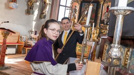 Armin Puschl beim Anzünden der Kerzen mit Laura, Ministrantin und Tochter, in Mieger 