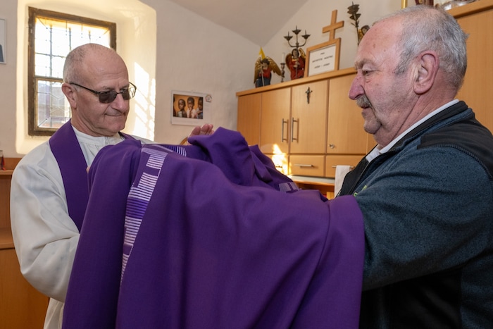 Gerhard Kropivnik ist Pfarrer Johann Alois Krištof beim Ankleiden behilflich.