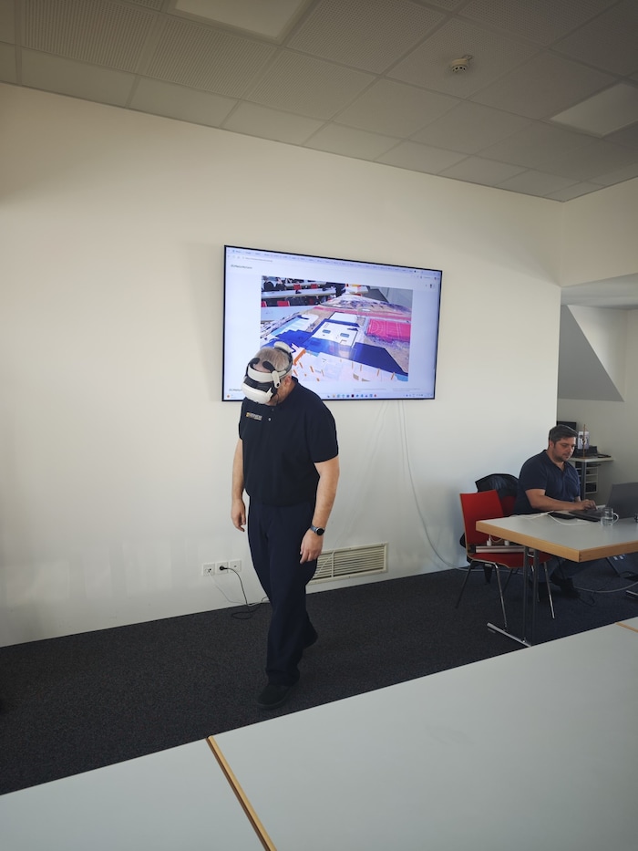 Was der Feuerwehrmann in der Brille sieht wird am Bildschirm dahinter dargestellt.