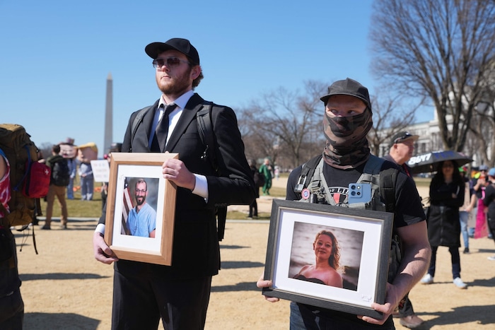 Demonstranten mit Bildern von Alex Pretti und Renee Good