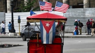 Kubanische und US-Flaggen schmücken ein Lastenrad in Havanna. Im Konflikt zwischen den Ländern ...