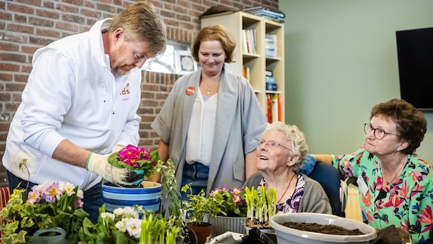 Der niederländische König Willem-Alexander (links) hilft am 13. März 2026 gemeinsam mit ...