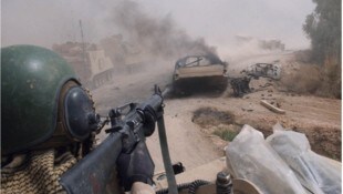 Ein amerikanischer Soldat richtet im Westen von Bagdad die Waffe auf ein Fahrzeug.