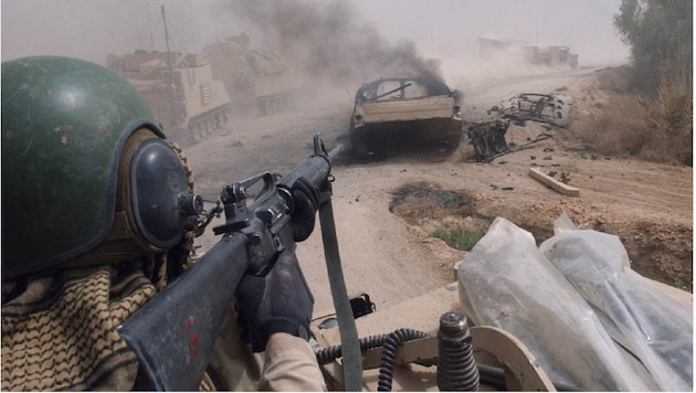 Ein amerikanischer Soldat richtet im Westen von Bagdad die Waffe auf ein Fahrzeug.