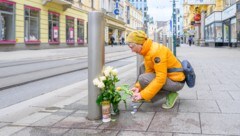 Am Tatort auf der Landstraße werden Blumen und Kerzen aufgestellt.