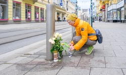 Am Tatort auf der Landstraße werden Blumen und Kerzen aufgestellt.