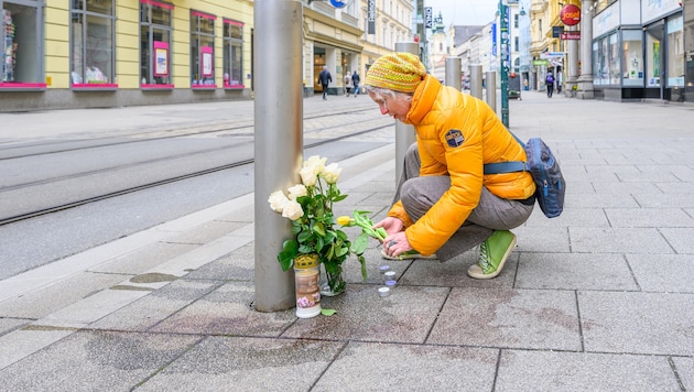 Am Tatort auf der Landstraße werden Blumen und Kerzen aufgestellt.