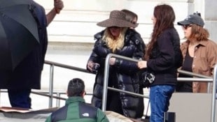 Die „Queen of Pop“ landet im schwarzen Puffer‑Look, versteckt hinter XXL‑Brille und ...