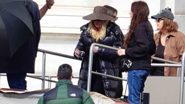 Die „Queen of Pop“ landet im schwarzen Puffer‑Look, versteckt hinter XXL‑Brille und ...