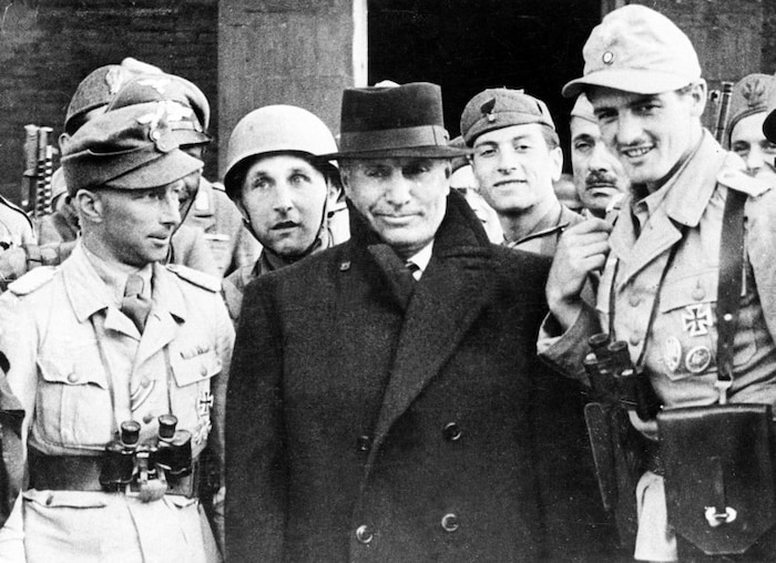 Benito Mussolini (m.) im September 1943 umringt von deutschen Fallschirmspringern
