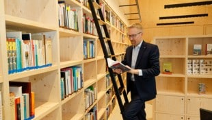 Direktor Peter Fritz schmökert in der neuen Bibliothek des Holzbaus.