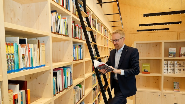 Direktor Peter Fritz schmökert in der neuen Bibliothek des Holzbaus.