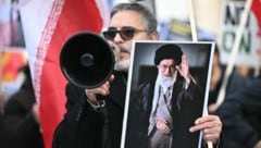 Ein Demonstrant hält ein Bild des getöteten Obersten Führers Ali Khamenei hoch.