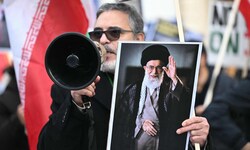Ein Demonstrant hält ein Bild des getöteten Obersten Führers Ali Khamenei hoch.