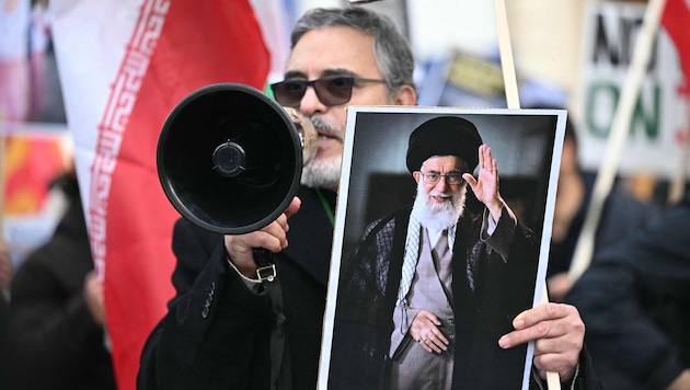 Ein Demonstrant hält ein Bild des getöteten Obersten Führers Ali Khamenei hoch.