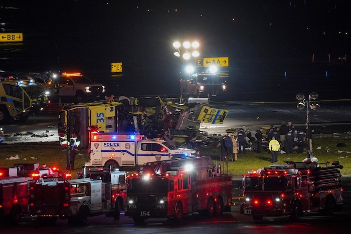 Emergency responders surround a wrecked fire truck.