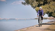 Radfahren in der Lagune von Venedig – im Hintergrund kann man Venedig erkennen. 