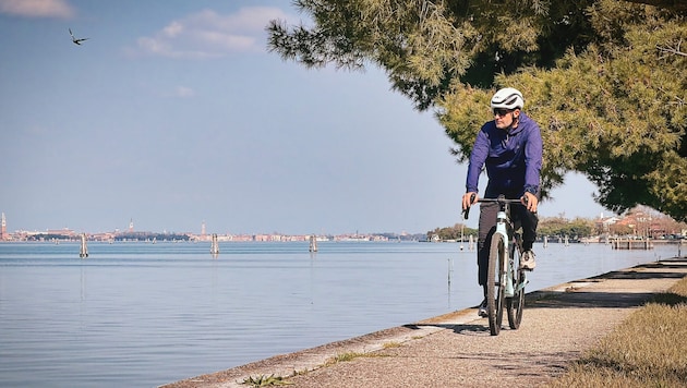 Radfahren in der Lagune von Venedig – im Hintergrund kann man Venedig erkennen.