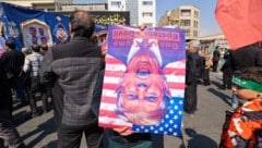 Regimetreue Demonstranten in Iran mit einem Porträt, das den US-Präsidenten als Teufel ...
