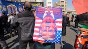 Regimetreue Demonstranten in Iran mit einem Porträt, das den US-Präsidenten als Teufel ...