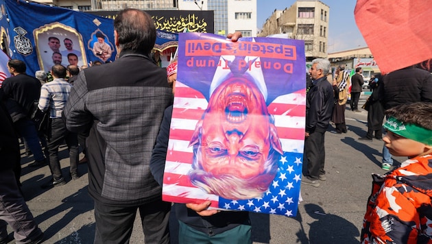 Regimetreue Demonstranten in Iran mit einem Porträt, das den US-Präsidenten als Teufel ...