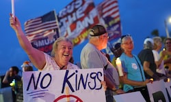 Eine Frau hält ein „No Kings“-Schild bei einer Pro-Demokratie-Demo vor dem Anwesen des ...